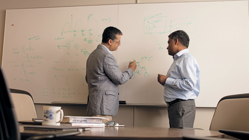 Interdisciplinary research pioneered by Garud Iyengar (right) and Vishal Misra (left) makes it possible to model the probability of intrusions. Their work makes use of machine learning to identify industry-wide vulnerabilities. (Photo by Jeffrey Schifman)